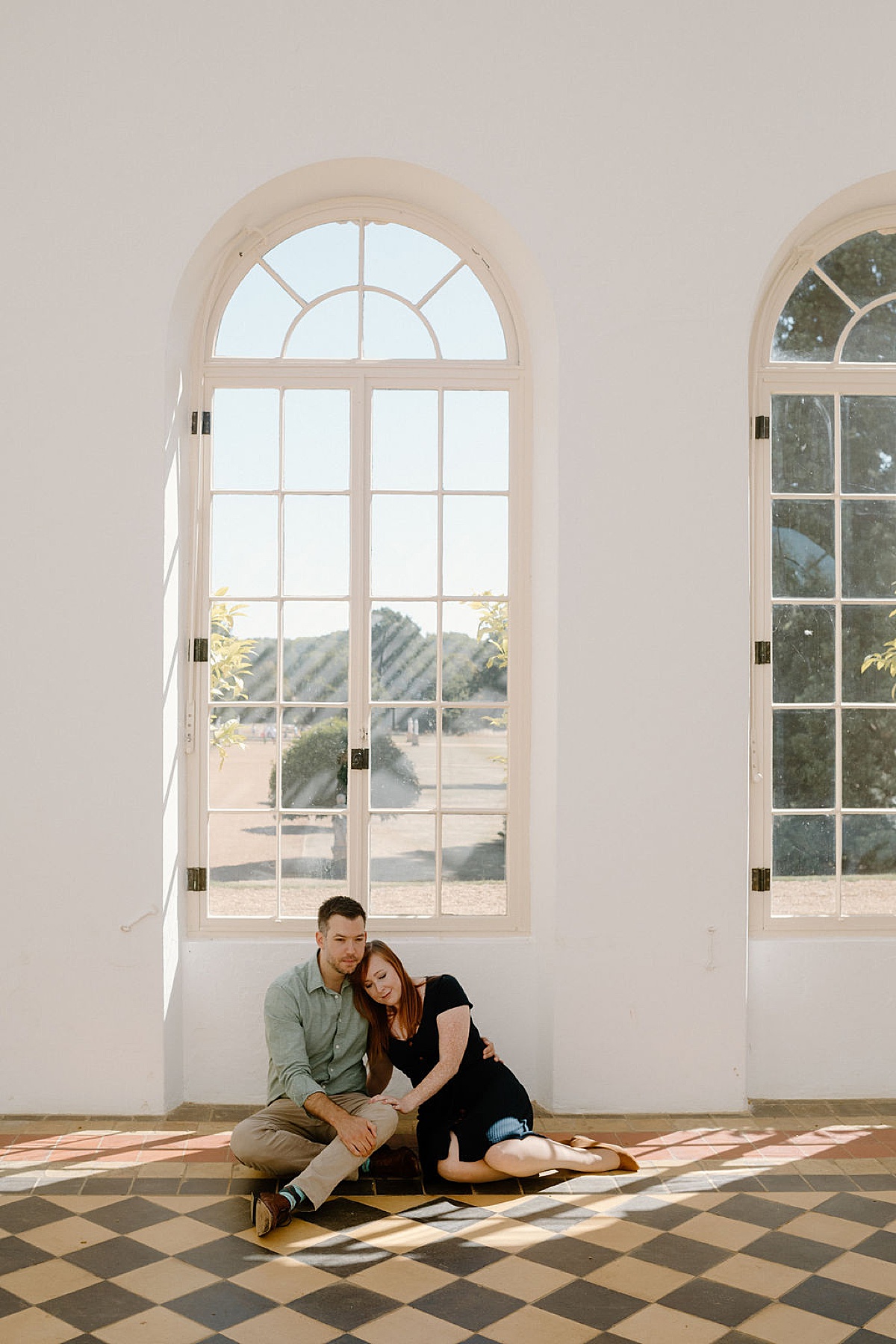 couple sit on tiled floor in garden pavilion during photoshoot with London Wedding Photographer