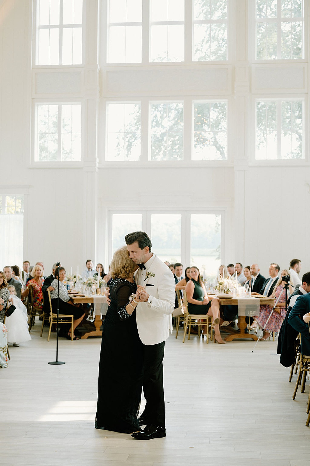 groom in white dinner jacket dances with his mother during reception shot by Michigan wedding photographer