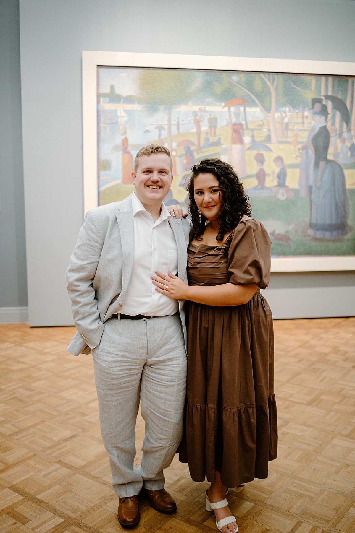 romantic couple in gray suit and flowy dress pose in art museum during photoshoot with Indigo Lace Collective