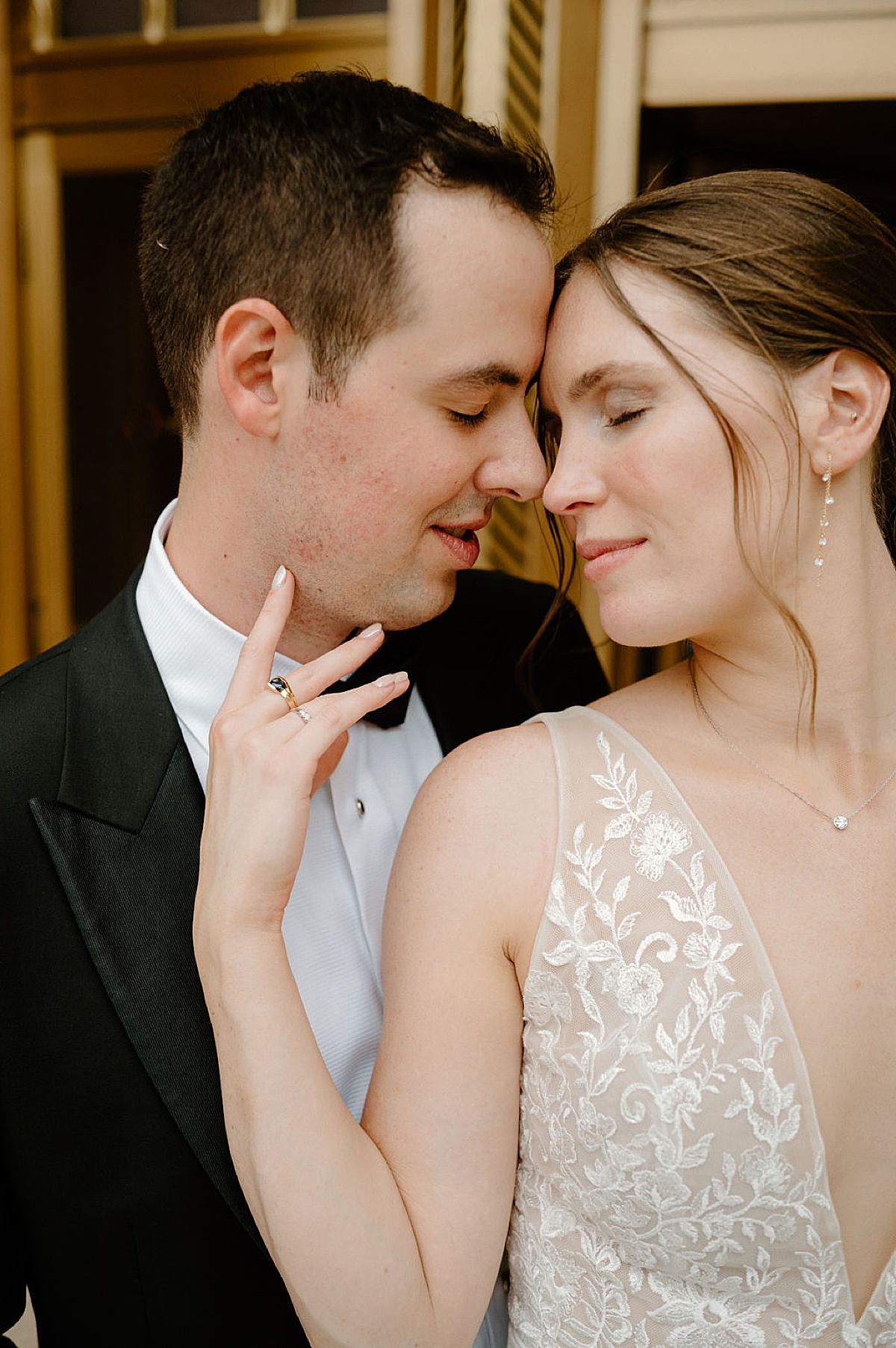 bride in sheer lace wedding gown and drop earrings poses with groom after Idyllic Fort Wayne country club wedding