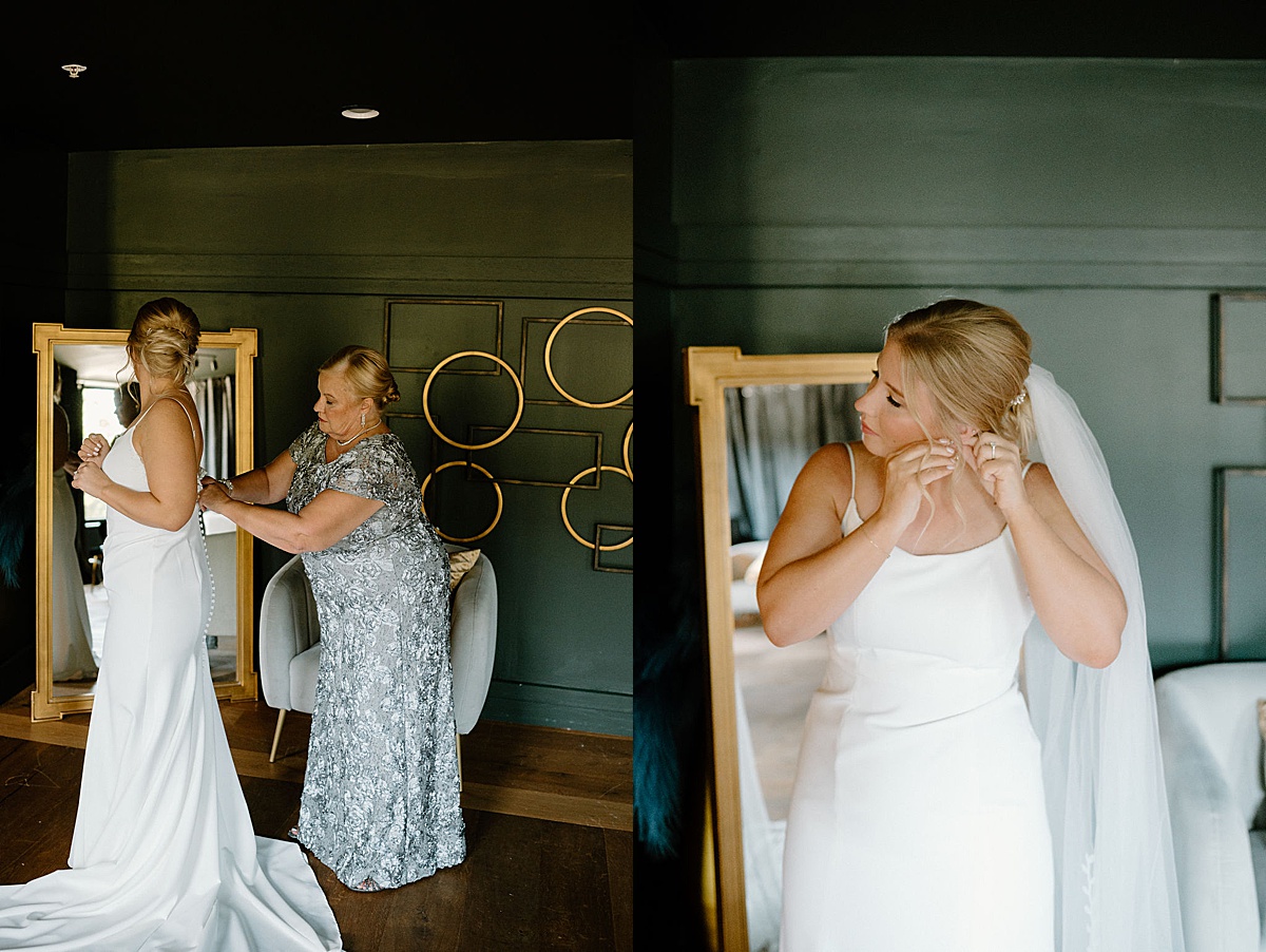 bride gets ready in moody mod hotel room with mother fastening her dress before intimate Chicago ceremony