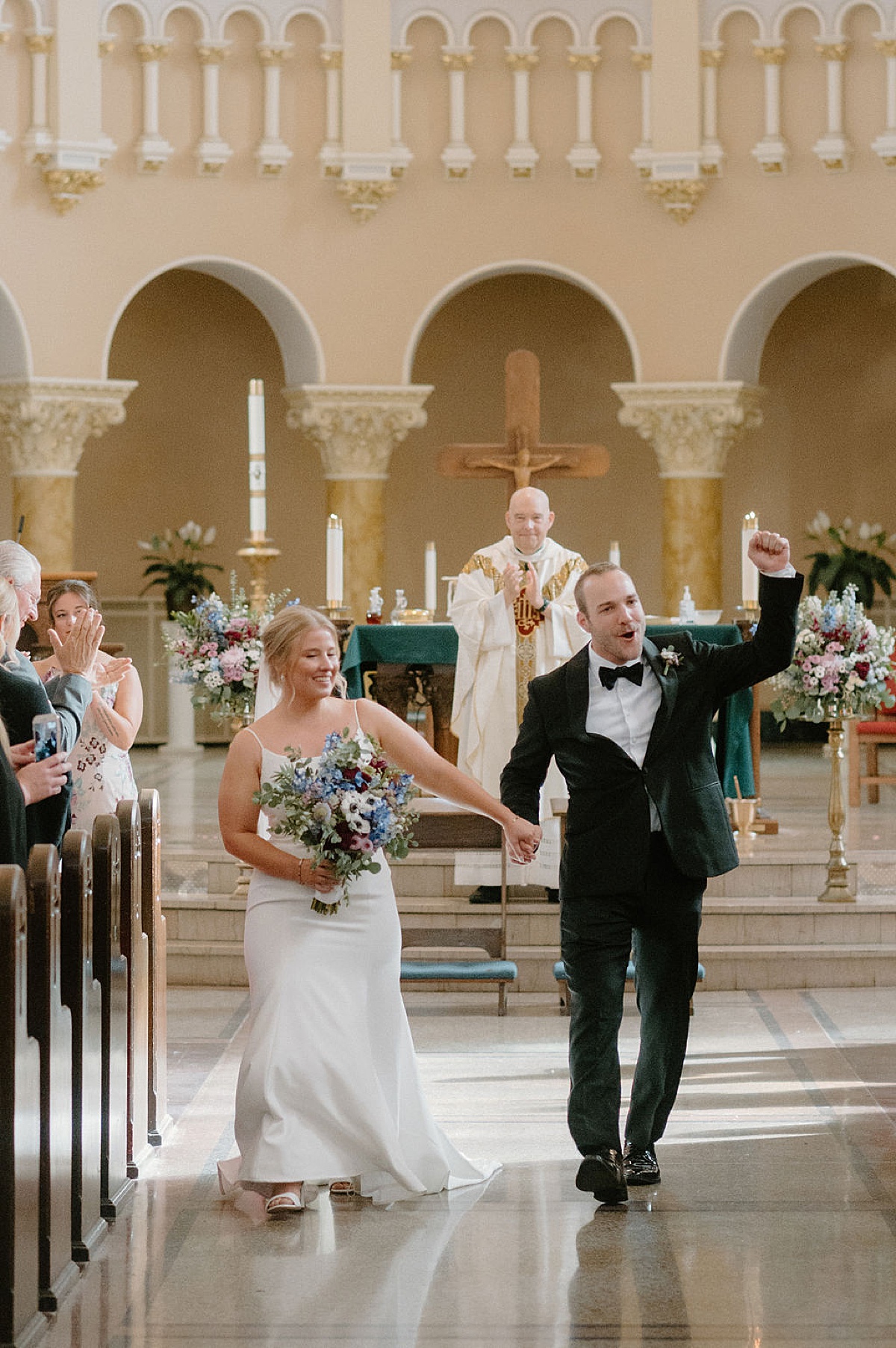 bride and groom walk back down the aisle after catholic wedding ceremony shot by Indigo Lace Collective