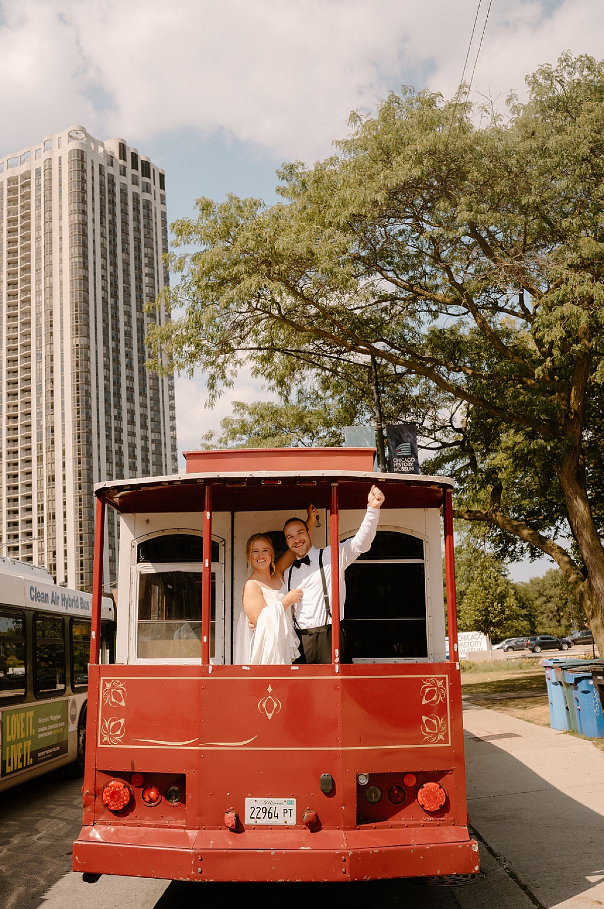 newlywed bride and groom ride a red trolley through the city after ceremony shot by Indigo Lace Collective