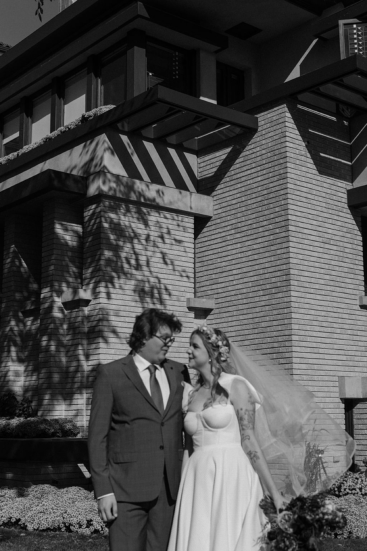 whimsical bride and groom pose outside Frank Lloyd Wright house for chicago wedding photographer