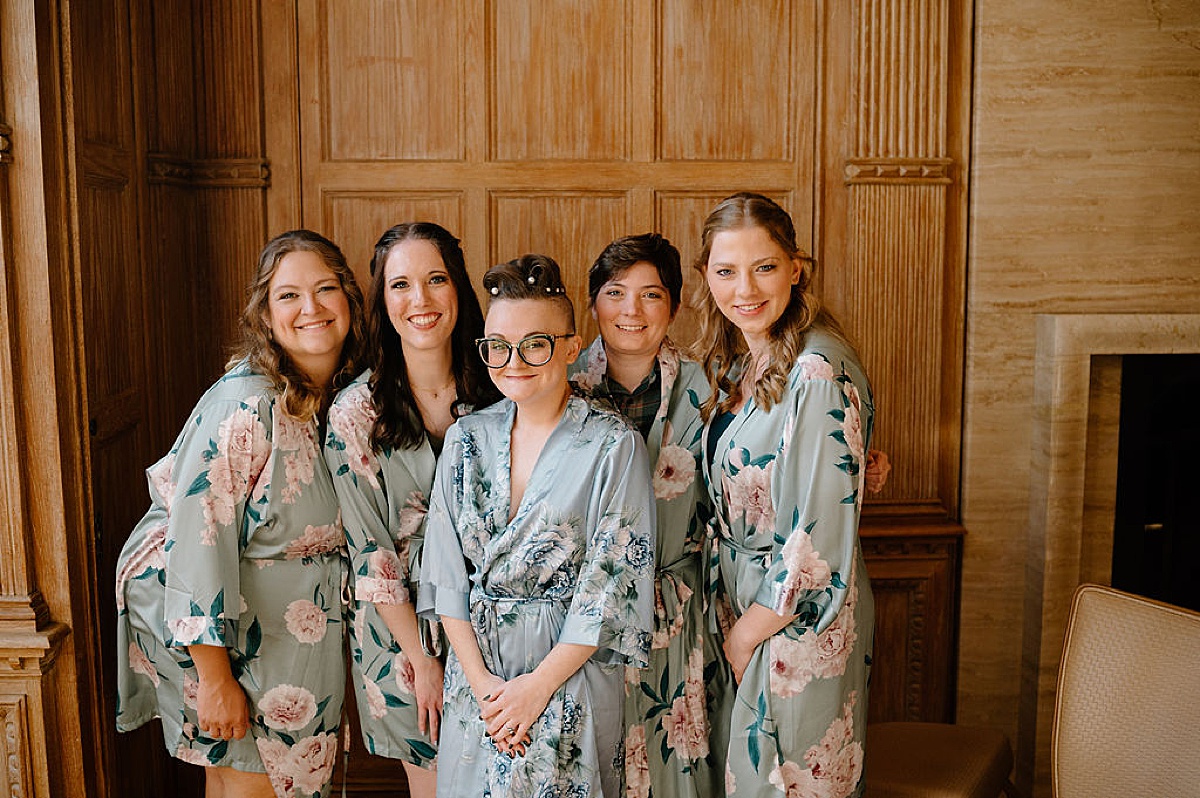 bride and bridesmaids get ready in cute floral satin robes before romantic autumn arboretum wedding