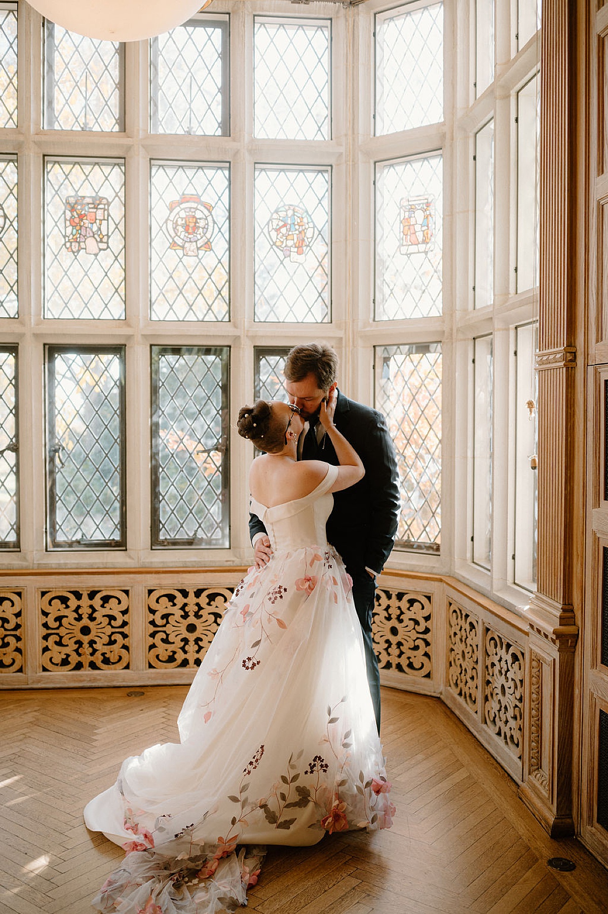 bride in amazing floral tulle gown kisses her groom in manor house after wedding shot by Indigo Lace Collective