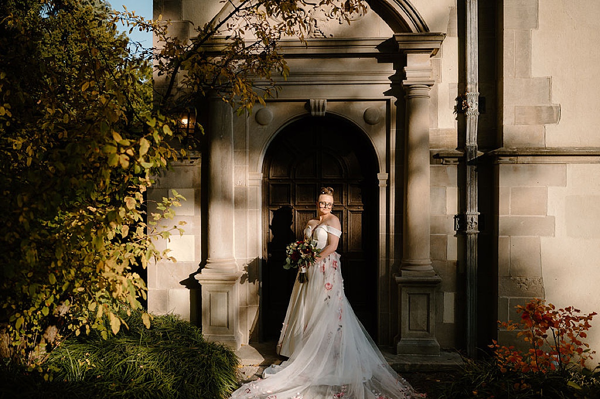 bride poses in gothic archway during shoot with midwest wedding photographer
