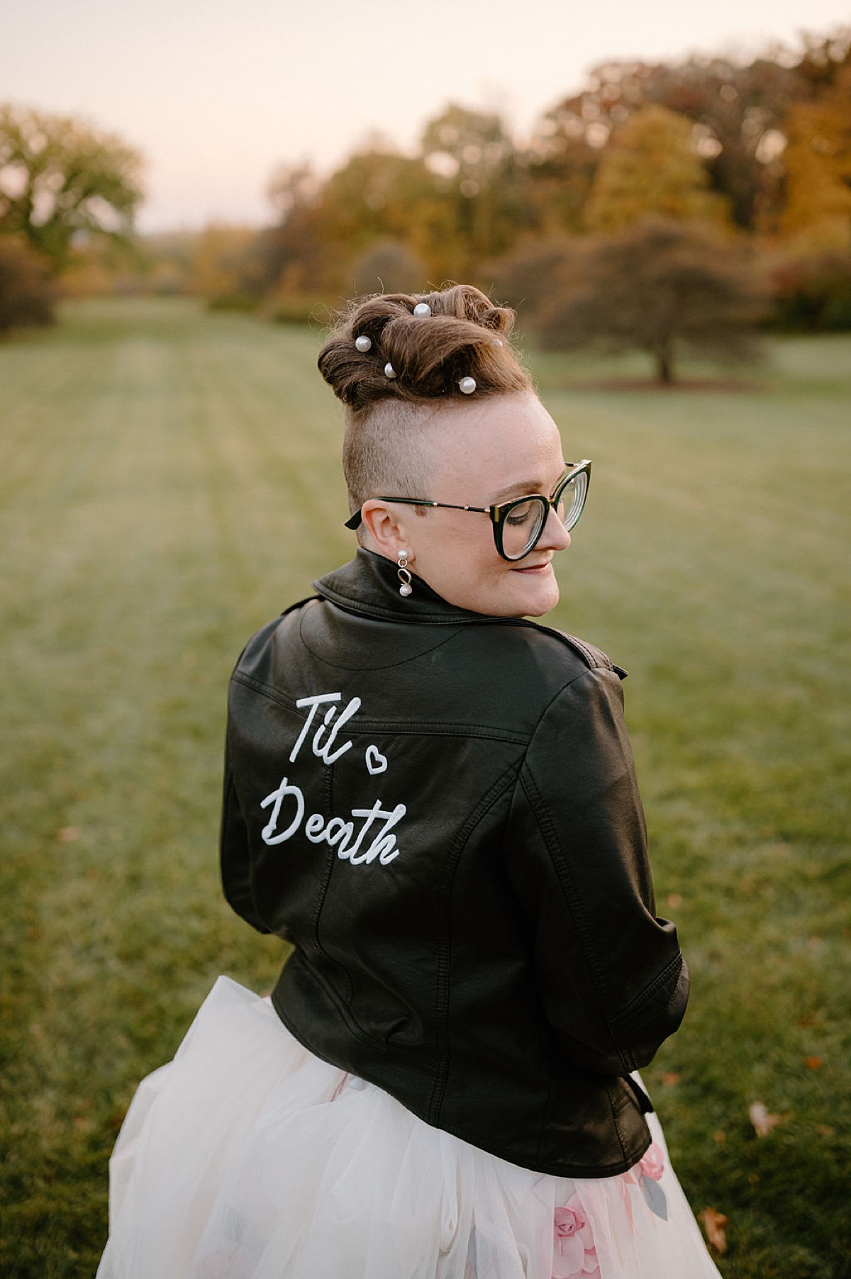 punk cute bride in leather til death jacket poses for midwest wedding photographer 