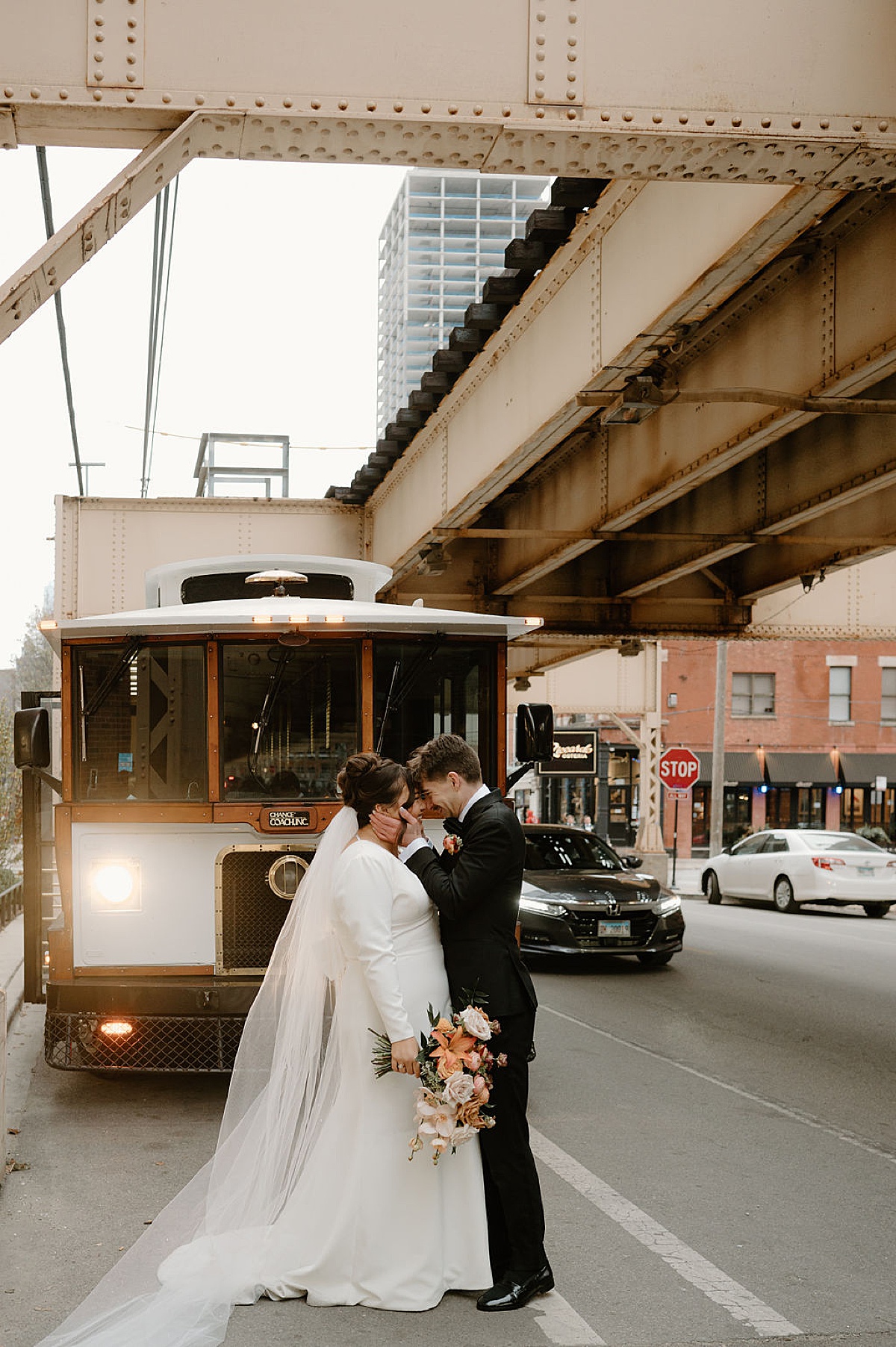 cute chicago bride and groom pose in front of trolley during session shot by Indigo Lace Collective