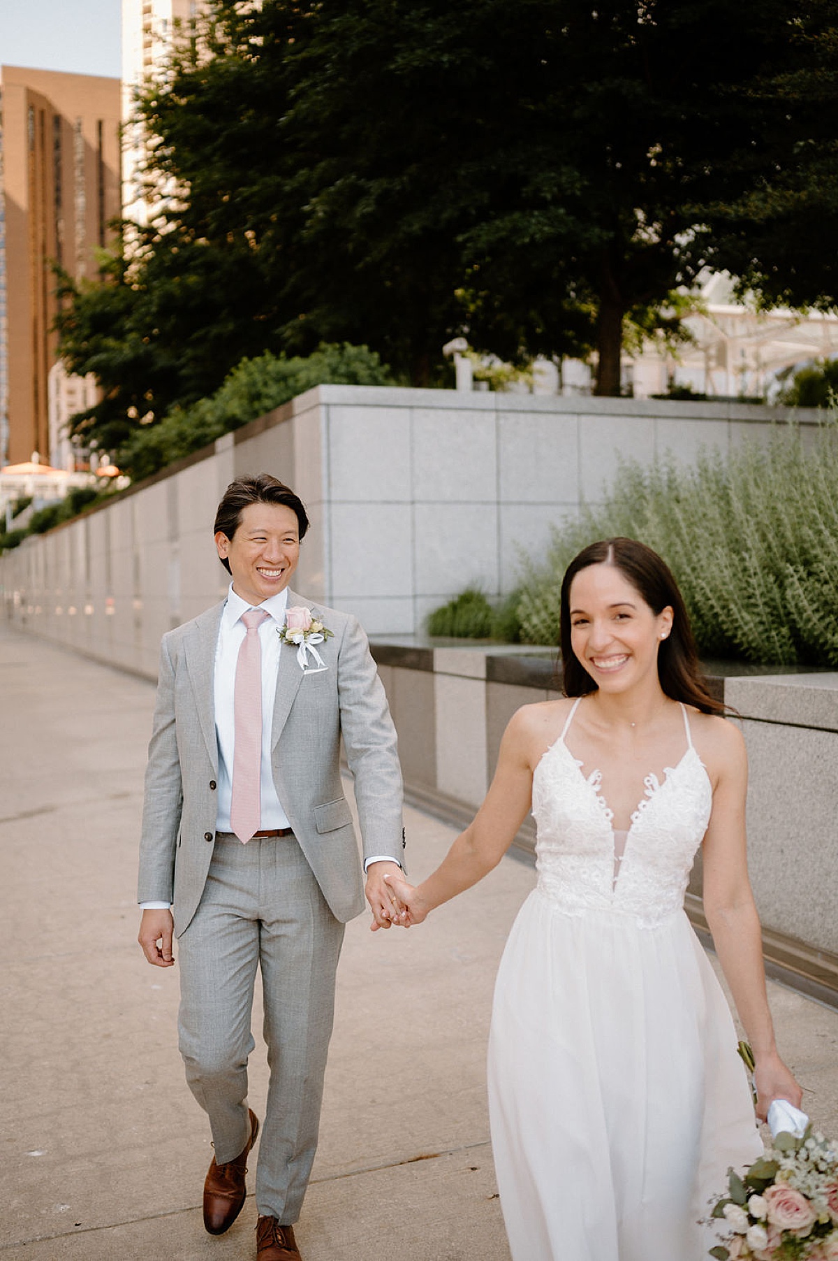 elegant spring bride and groom walk hand in hand through the city after elopement shot by Indigo Lace Collective