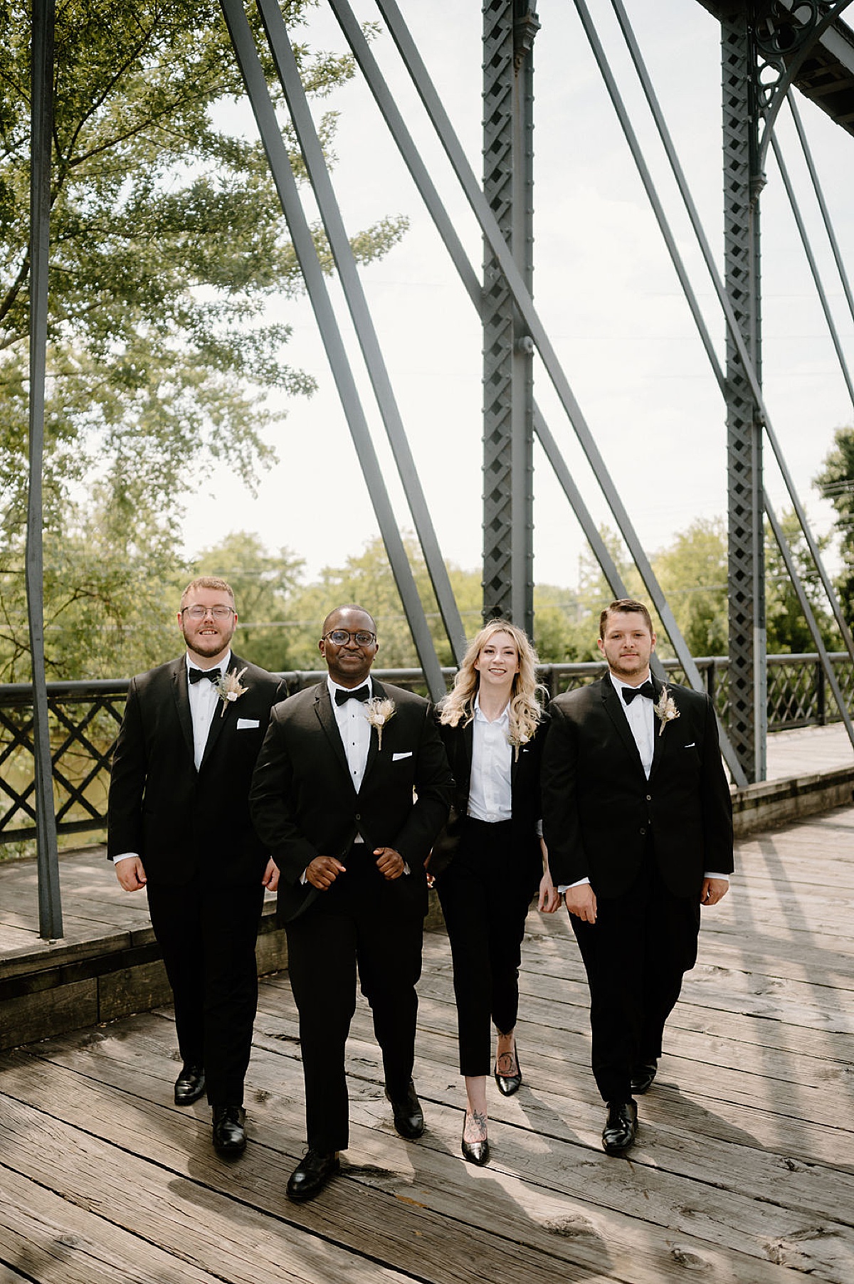 groom and attendants walk toward the camera before summer wedding in fort wayne shot by Indigo Lace Collective