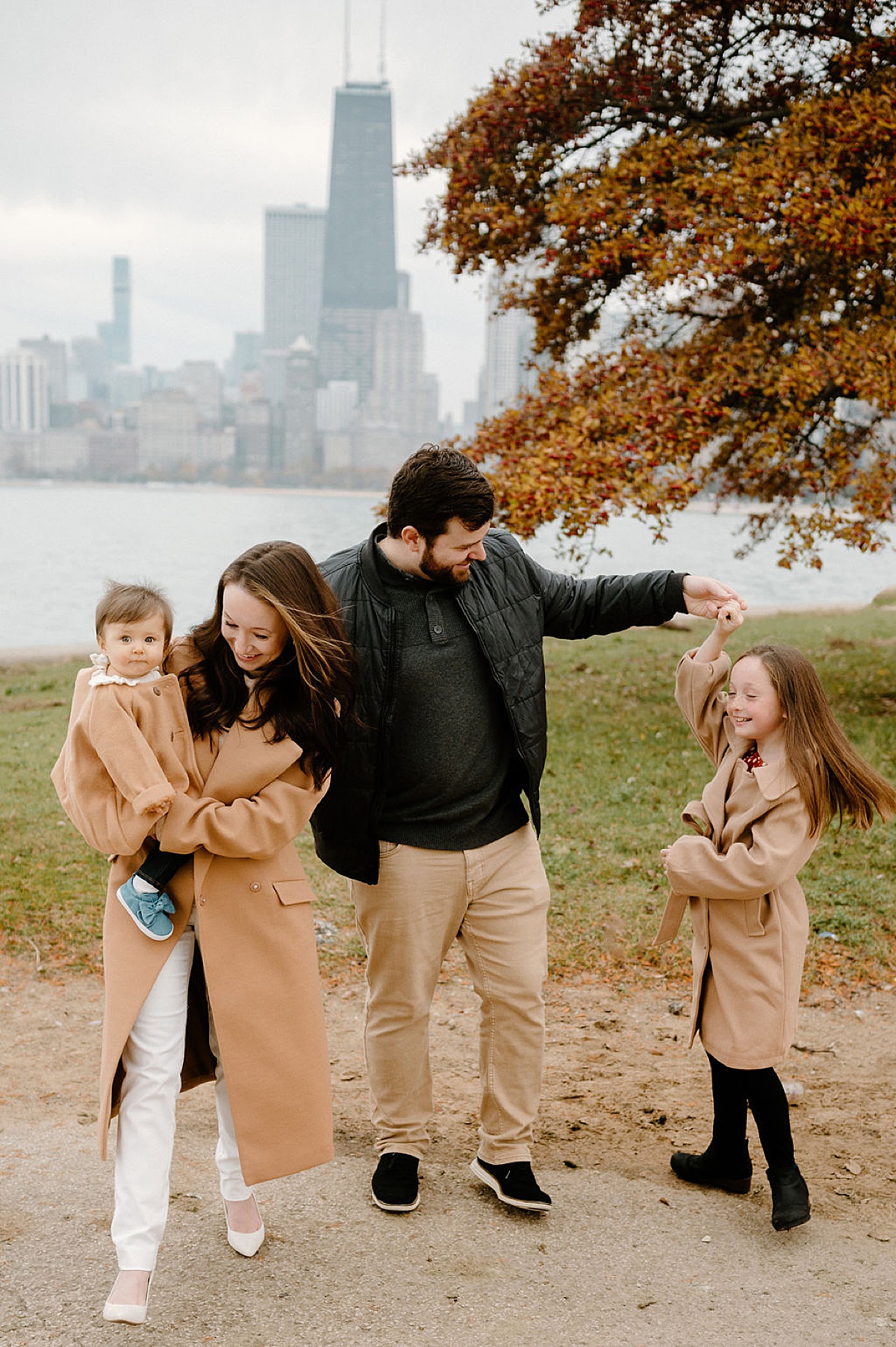 cute family playfully walk through fall leaves during shoot with Chicago family photographer