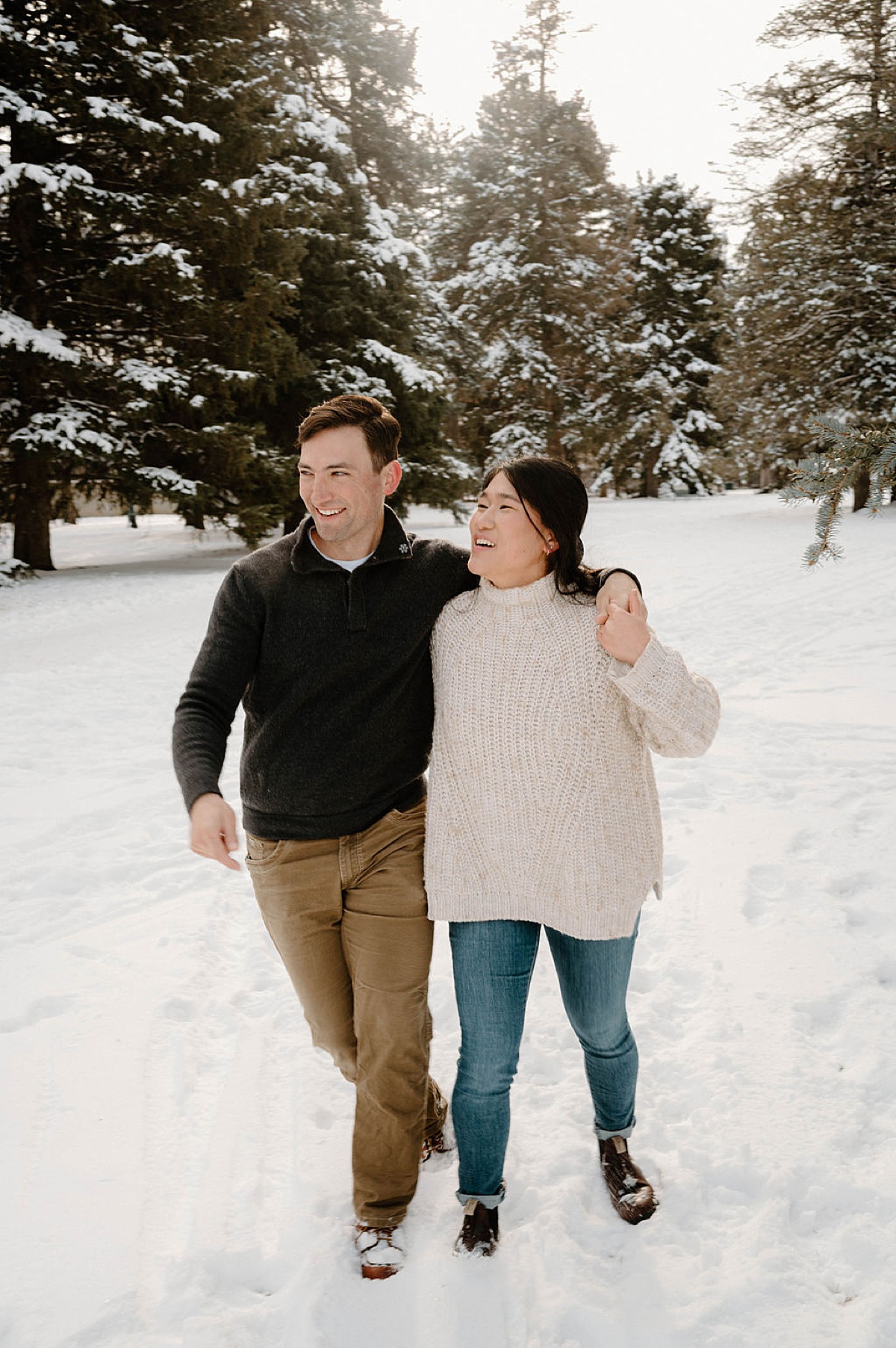 outdoorsy Colorado couple hike through snowy park during engagement shoot with Indigo Lace Collective