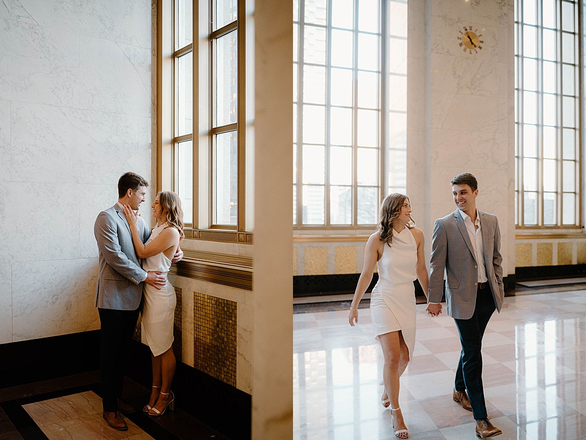 woman in white dress walks hand in hand with finace in gray jacket during chic post office engagement session