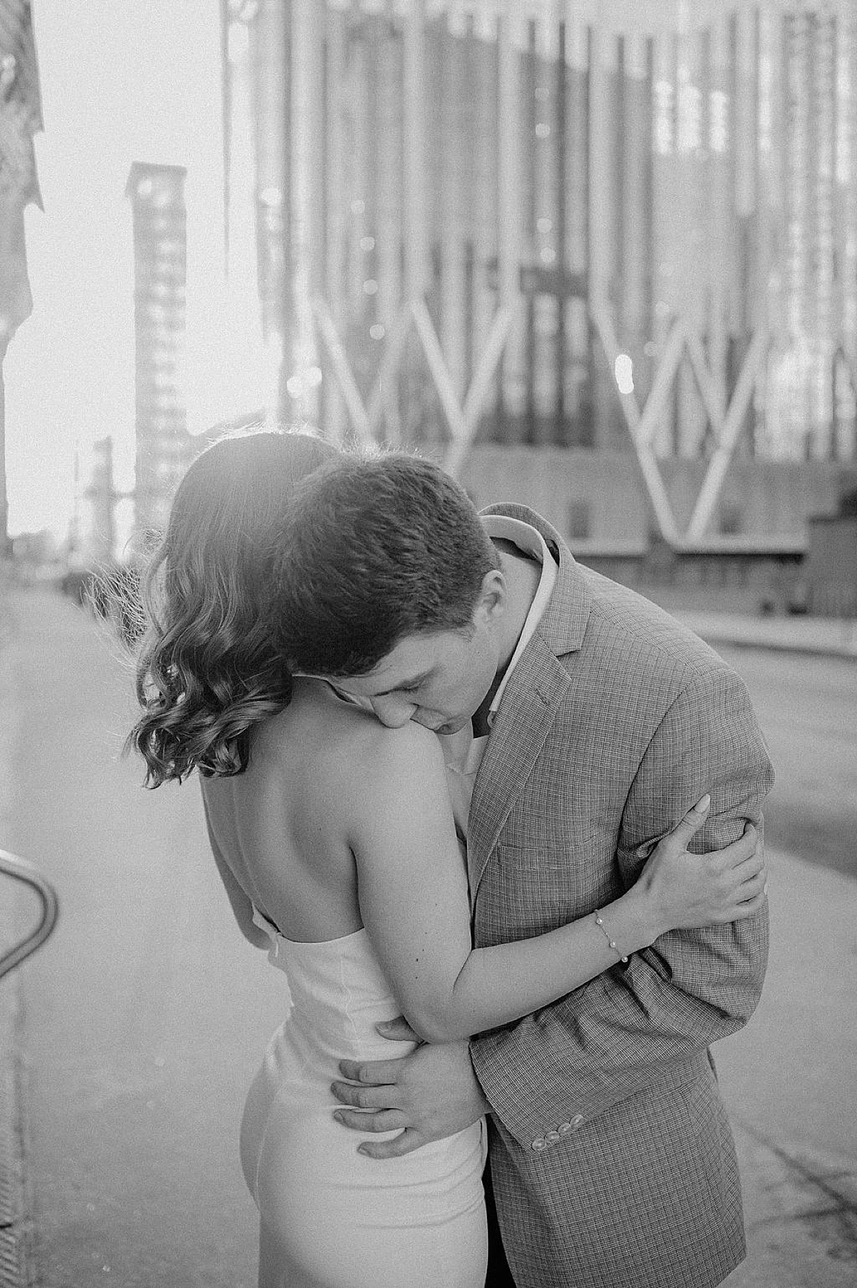 man kisses his fiancee on the shoulder during classy engagement shoot with Chicago wedding photographer