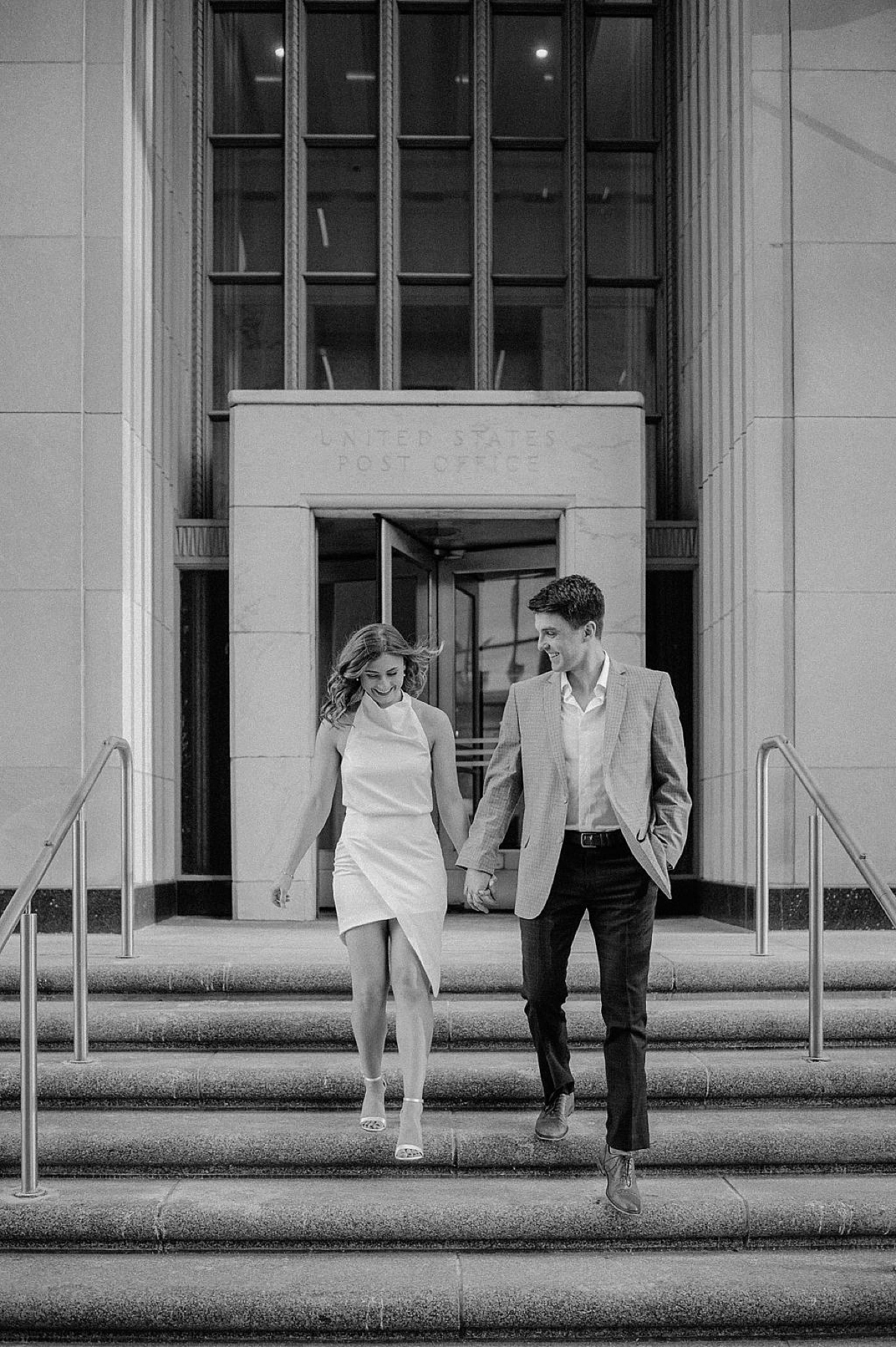 classy young couple walk hand in hand outside iconic post office in Chicago during shoot with Indigo Lace Collective