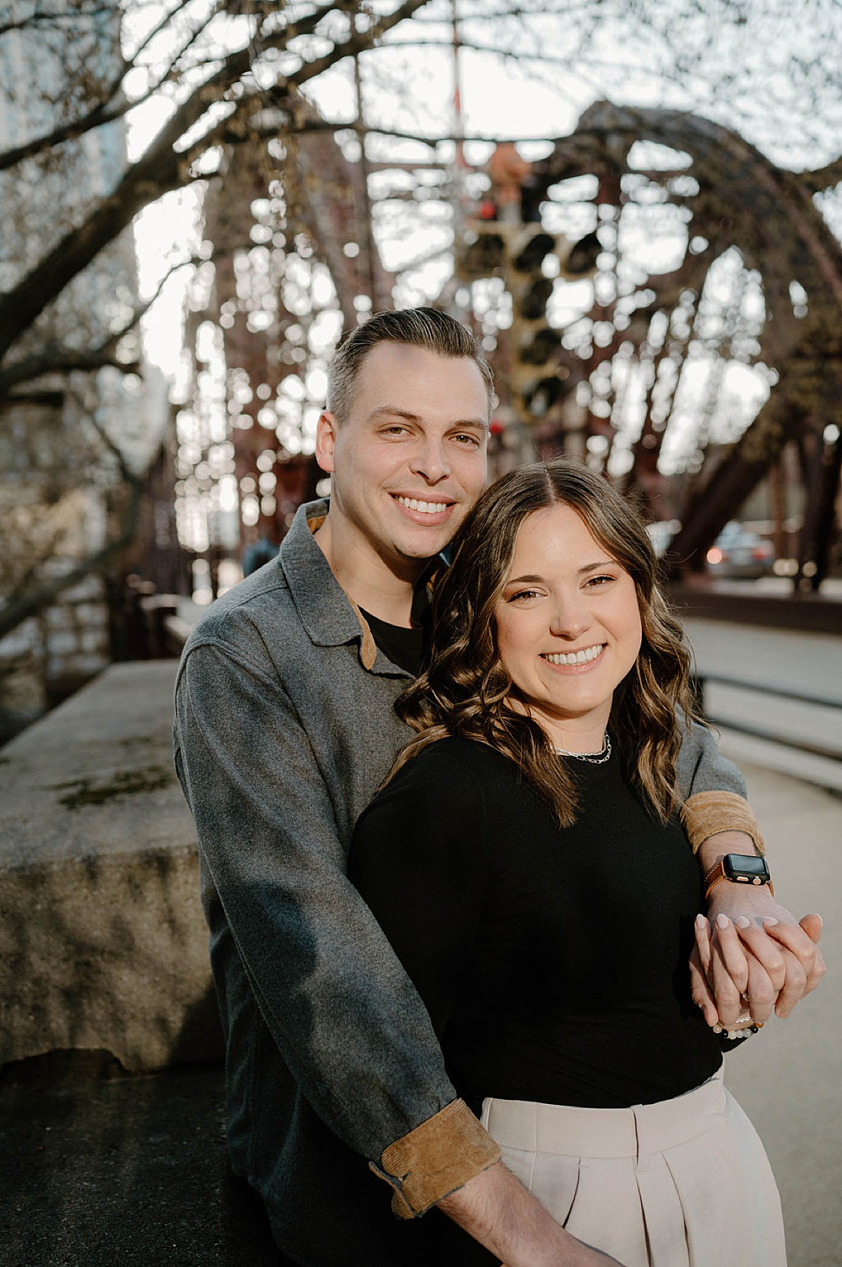 cute couple embrace and pose on iron bridge during west loop city engagement shoot