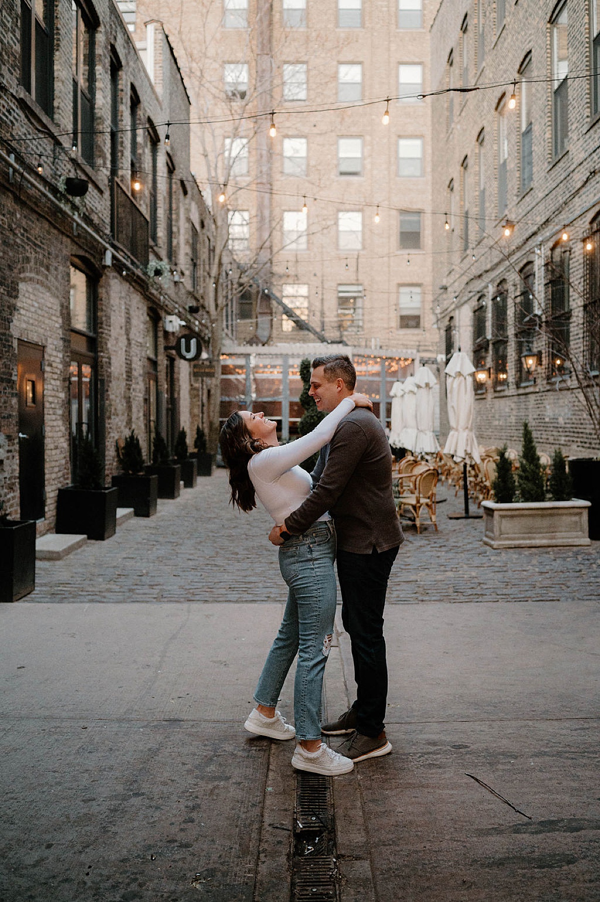 young couple dance in yard restaurant during cute engagement photos taken by Indigo Lace Collective