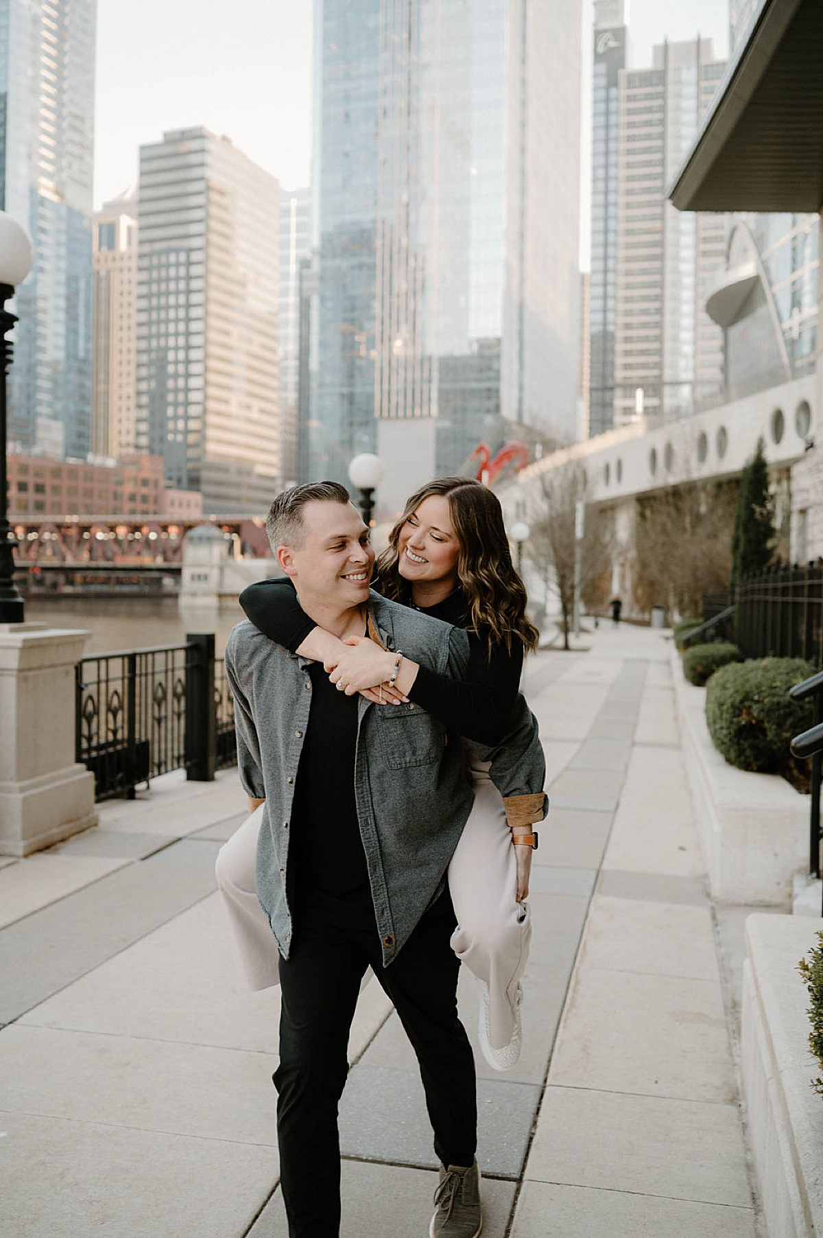 fiance carries his girl in piggyback during fun engagement shoot with chicago wedding photographer