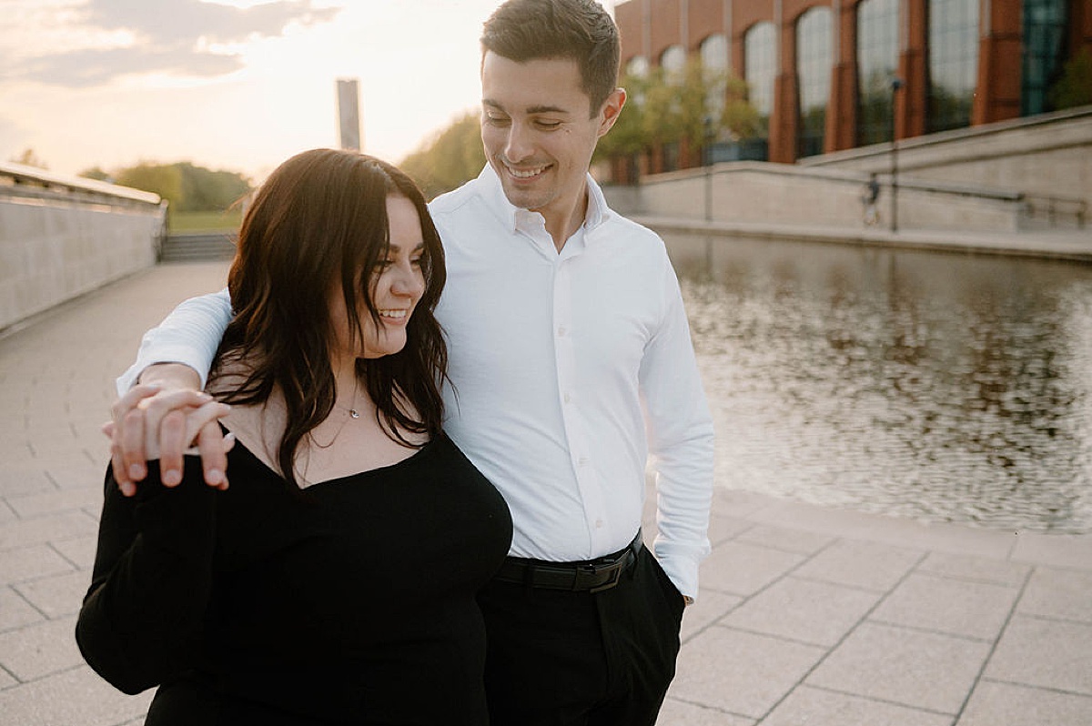 Cute couple walk through city during Indianapolis sunset engagement shoot