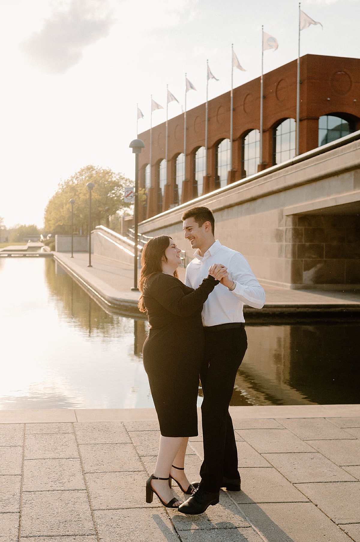 Cute couple walk hand in hand through street during Indianapolis sunset engagement shoot