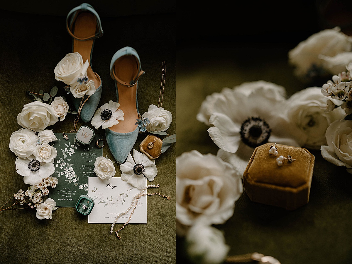 white roses and poppies are scattered around pastel wedding accessories and stationary before spring wedding at Artifact Events