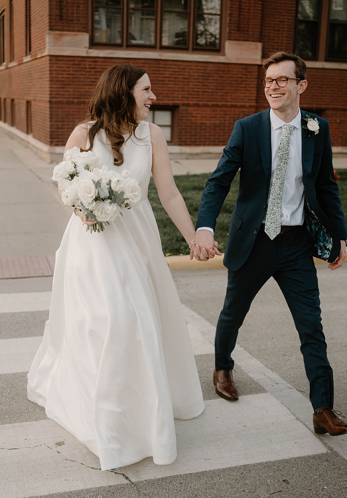 bride and groom walk hand in hand down the street after ceremony shot by Chicago Wedding photographer
