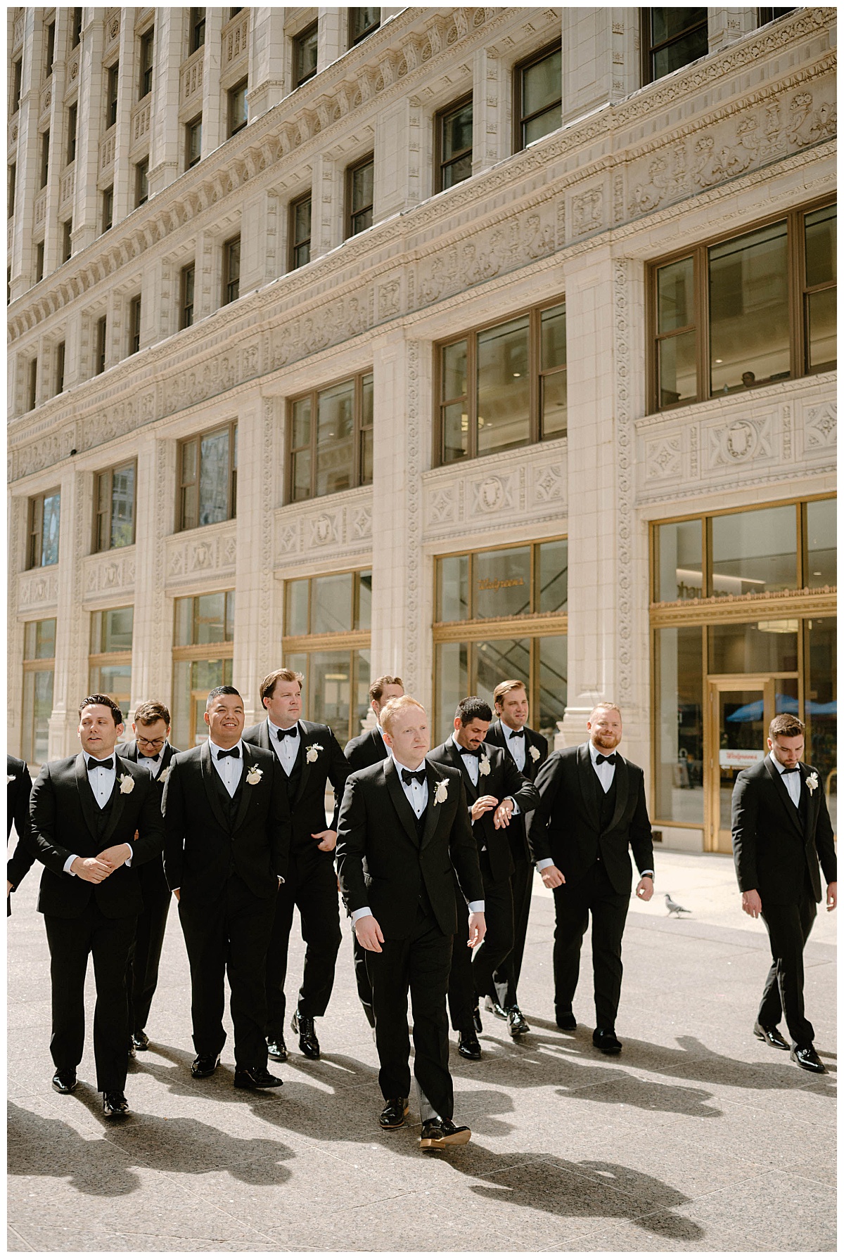 groomsmen walk down sidewalk with groom by Indigo Lace Collective