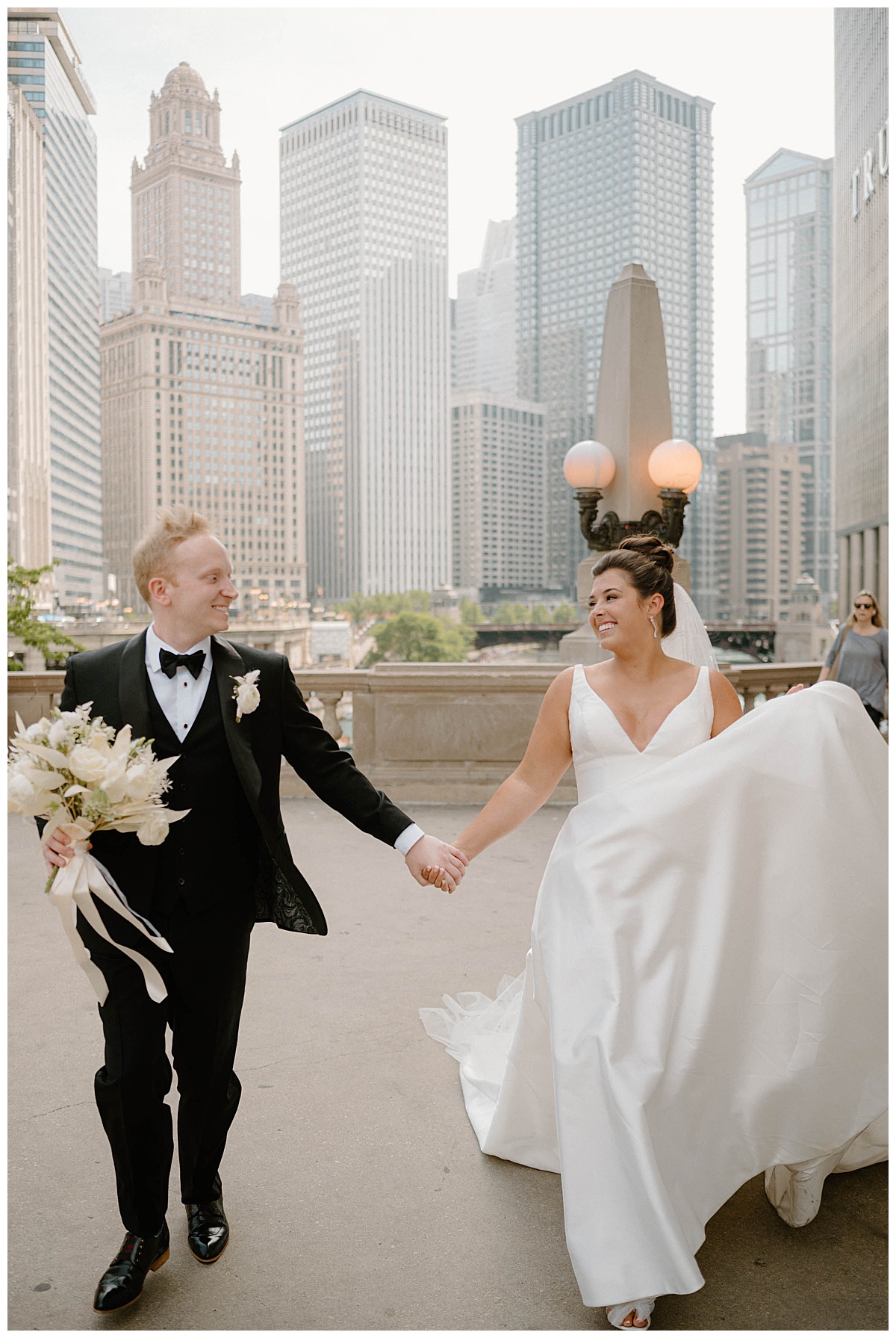 newlyweds grin walking hand in hand by Chicago photographer