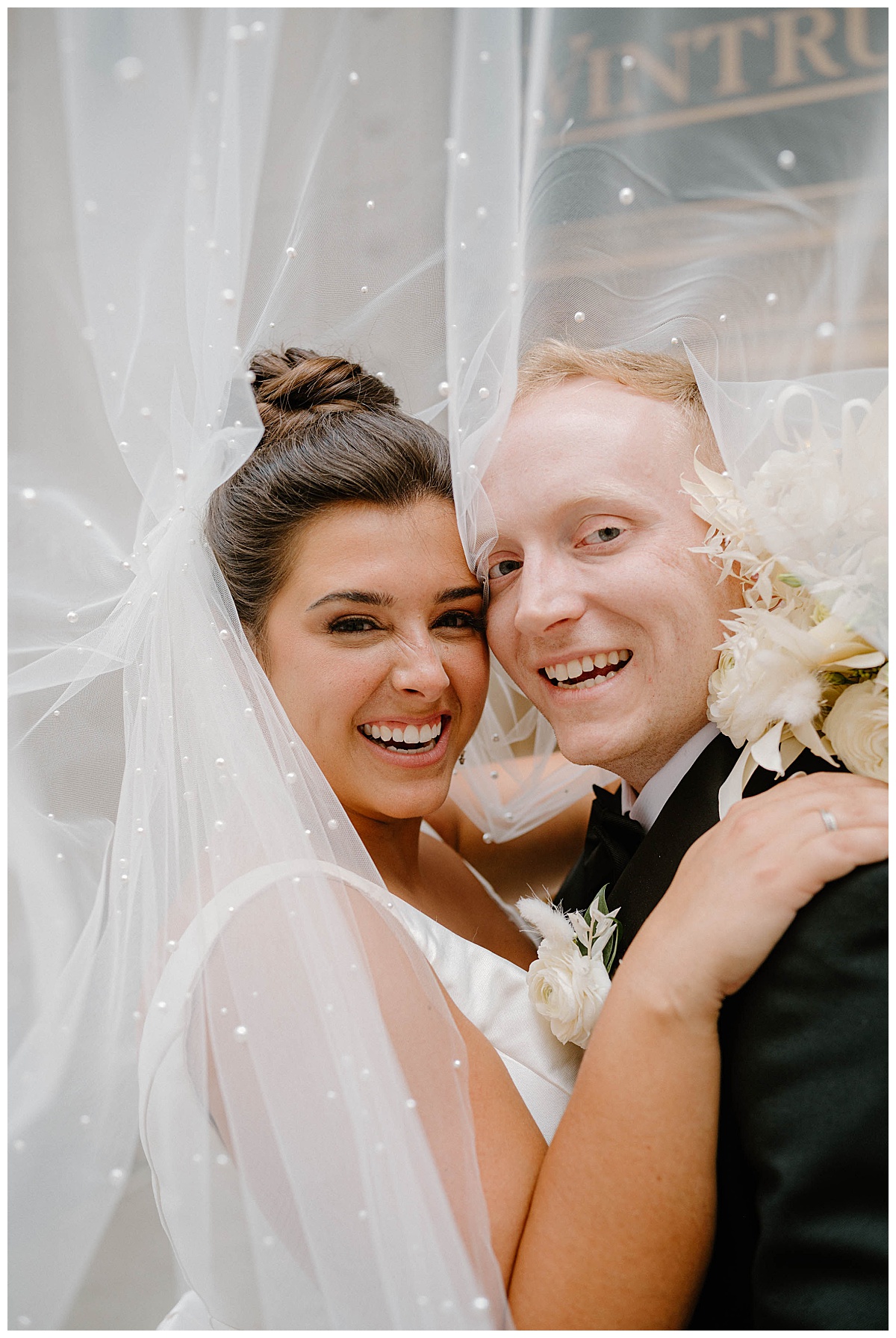 man and woman smile with heads together under bridal veil by Chicago photographer