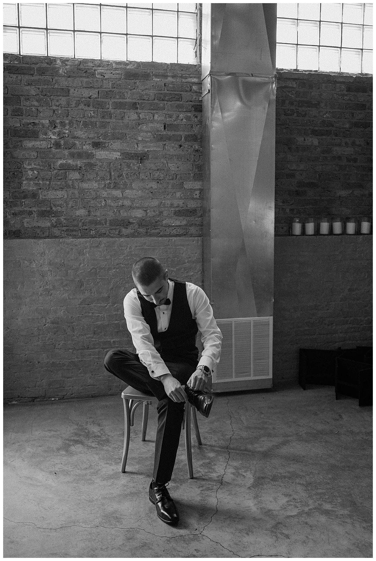 groom ties his shoes on chair by Chicago photographer