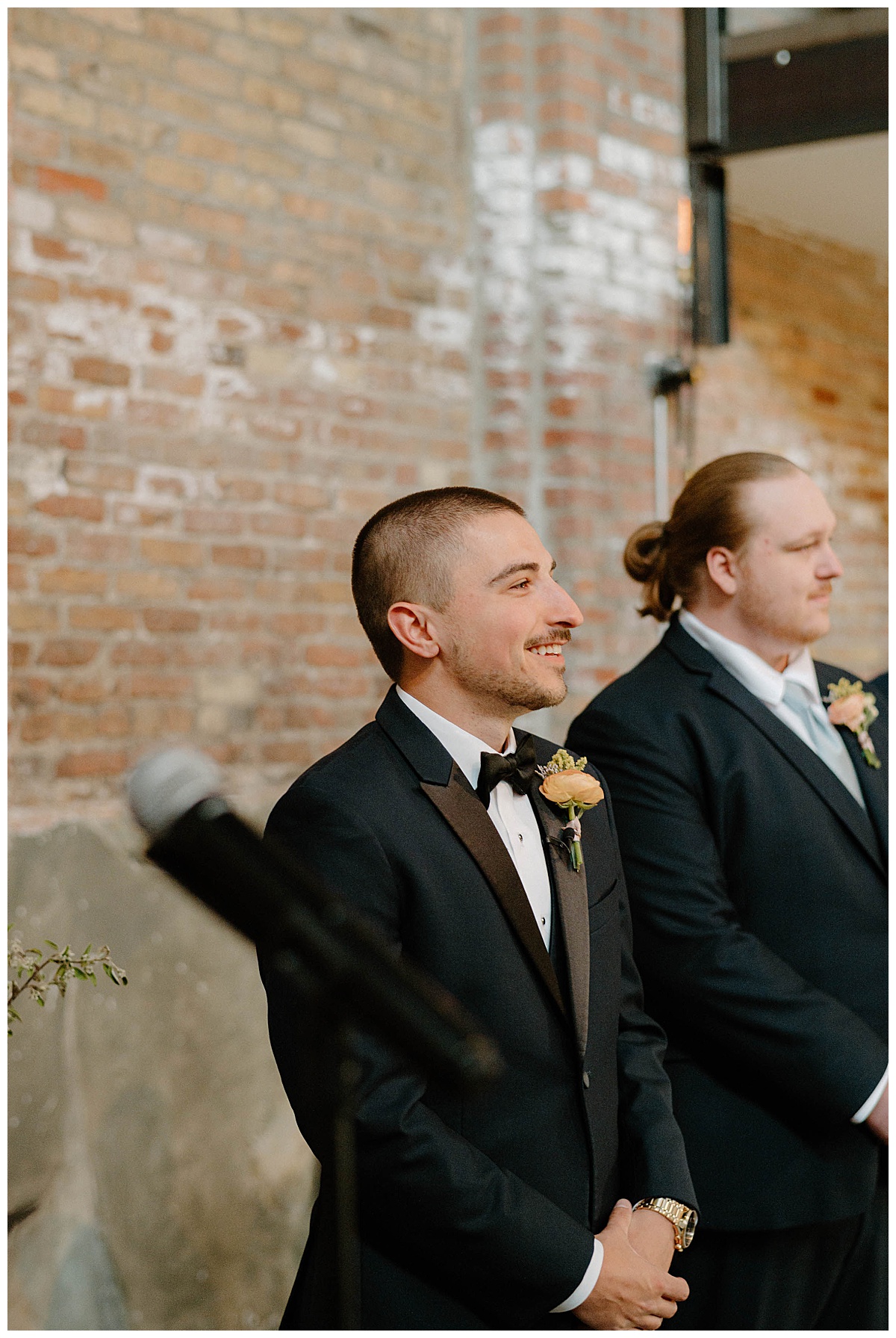 groom smiles as he sees bride walk down aisle by Indigo Lace Collective