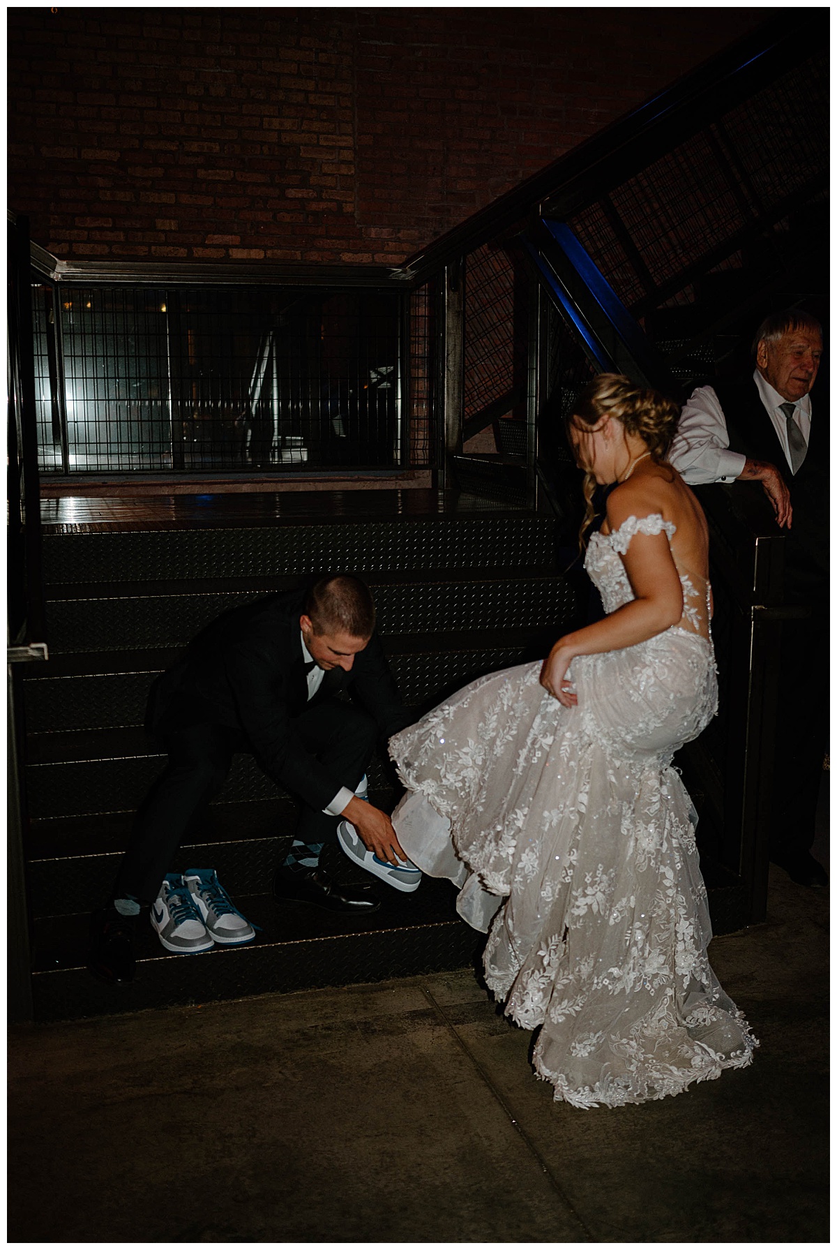 man helps woman change into comfortable shoes at summer Fairlie wedding