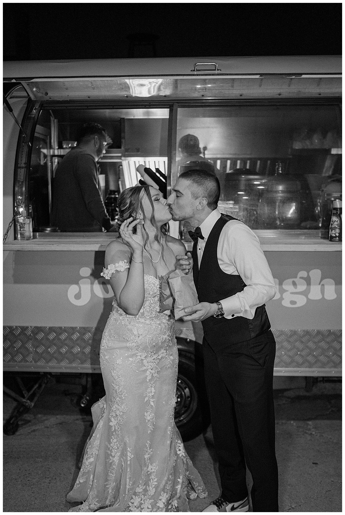 newlyweds kiss while eating donuts in front of donut cart by Chicago photographer