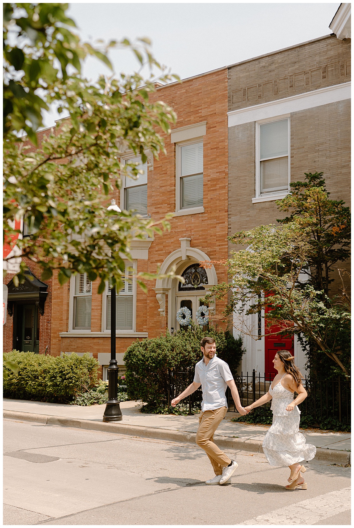 couple runs across the street holding hands by Chicago wedding photographer