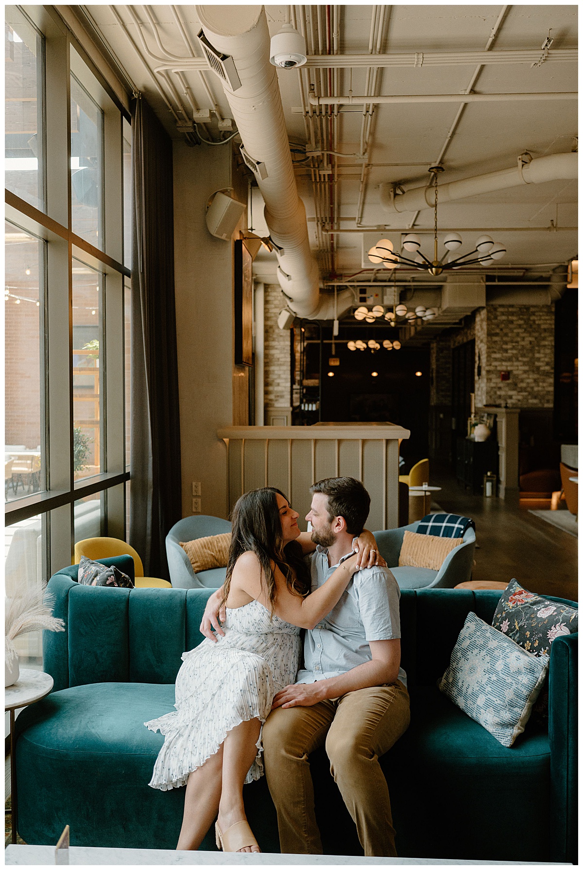 couple sits on couch with arms around each other by Chicago wedding photographer