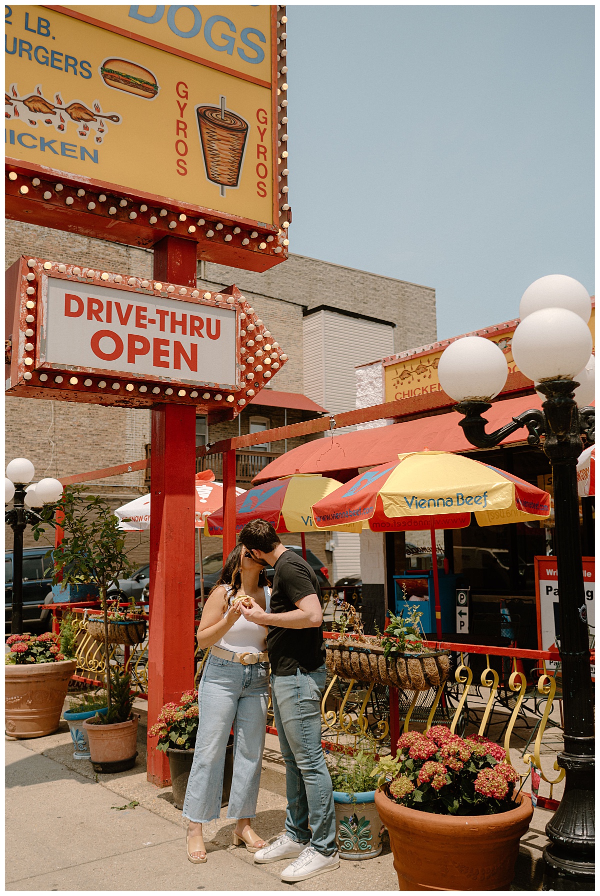 bride and groom to be kiss under drive thru restaurant sign by Indigo Lace Collective
