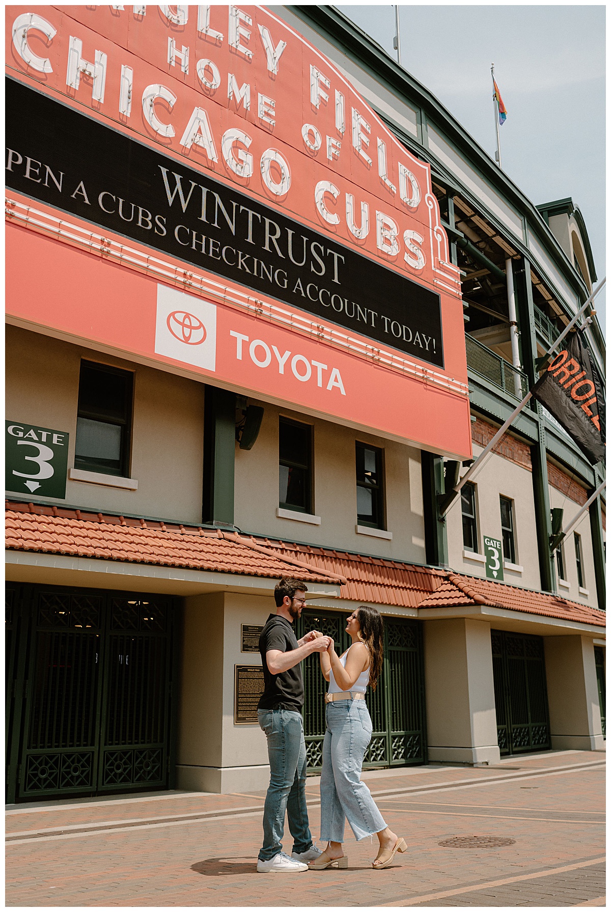 man and woman dance under sign at Wrigley Field engagement session
