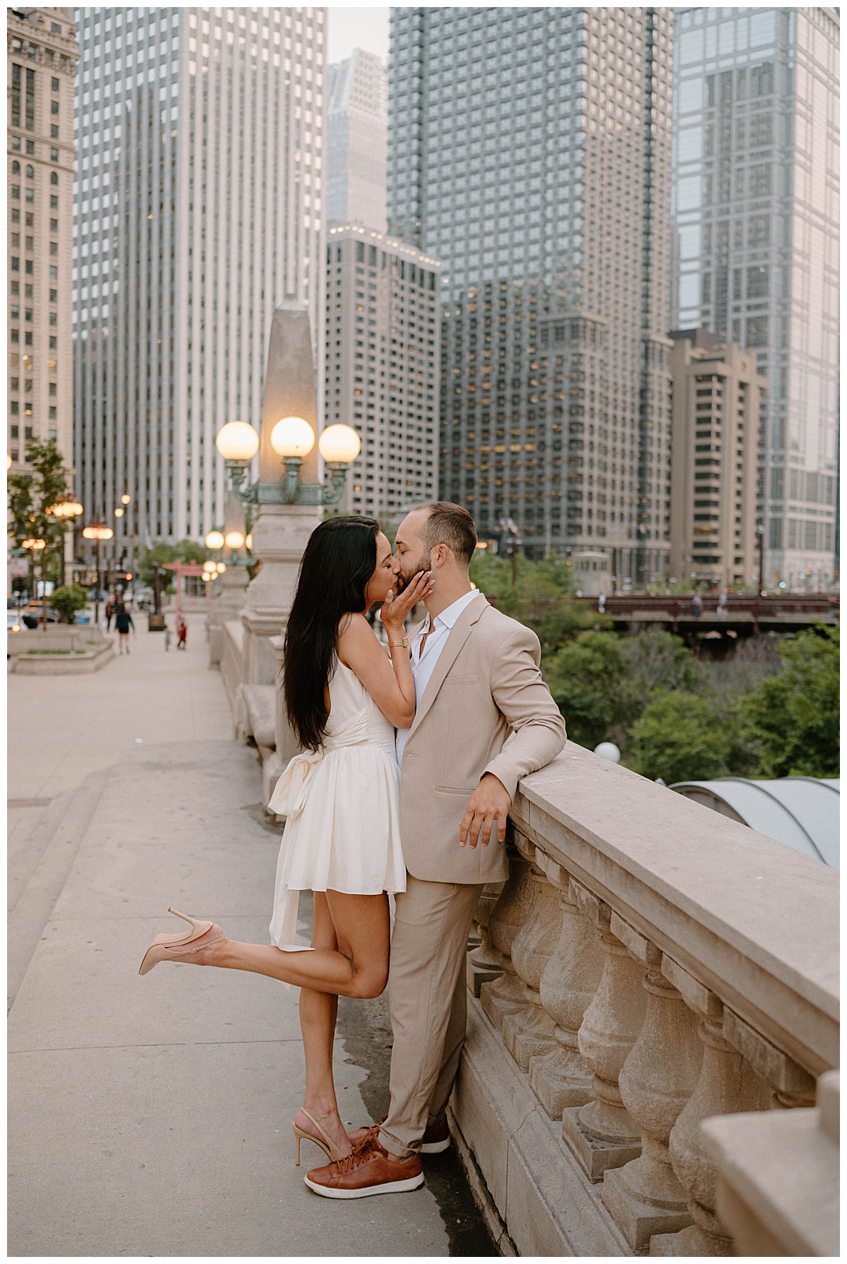 fiancés kiss on bridge over river by Chicago wedding photographer