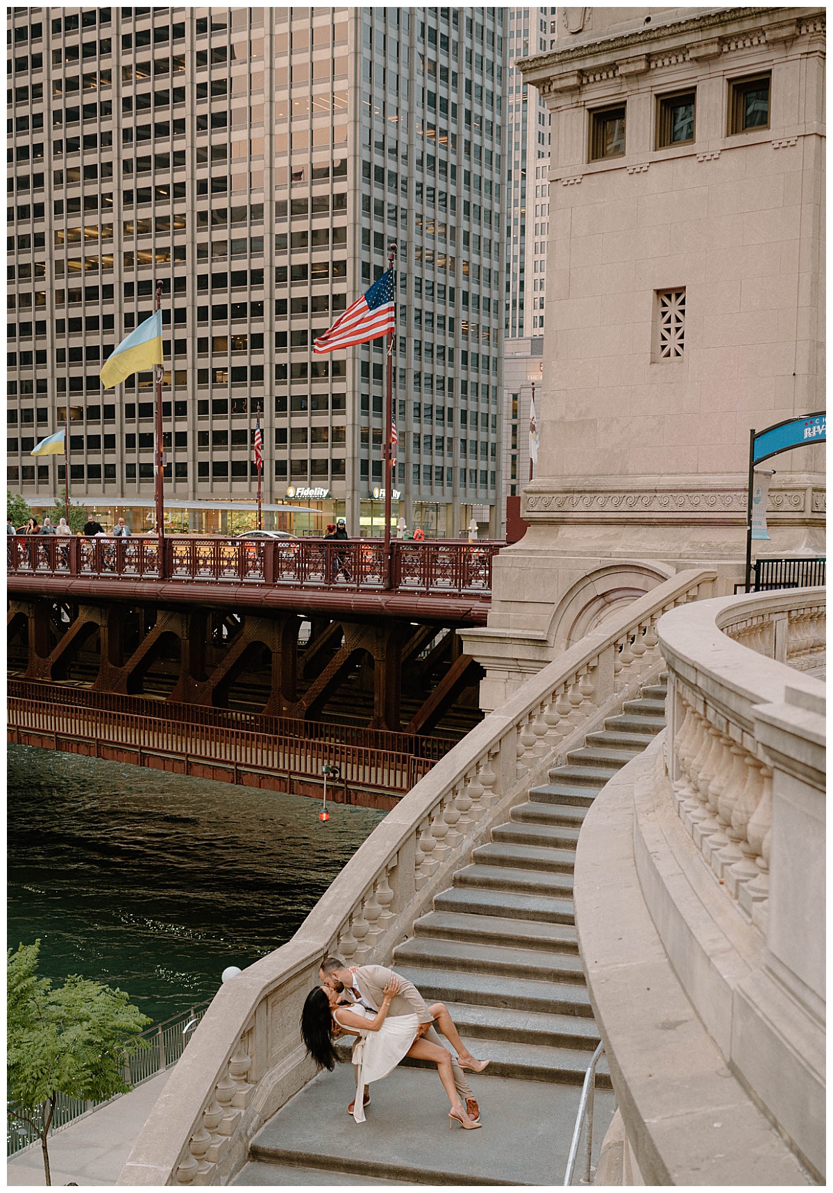 man dips woman and kisses her on grand staircase by Chicago wedding photographer