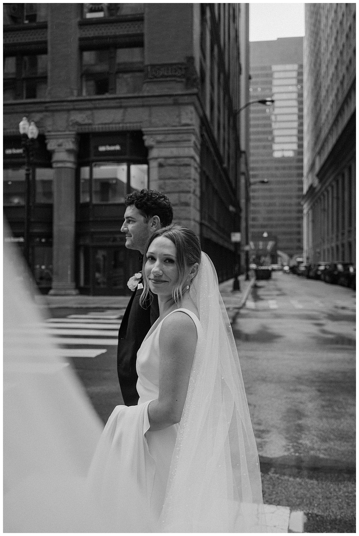 wife looks to side while she walks with new husband by Midwest wedding photographer