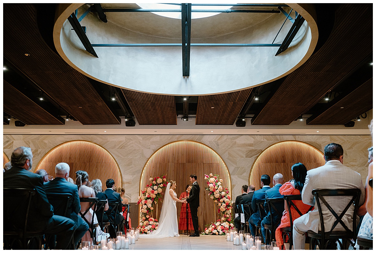bride and groom hold hands at altar by Indigo Lace Collective