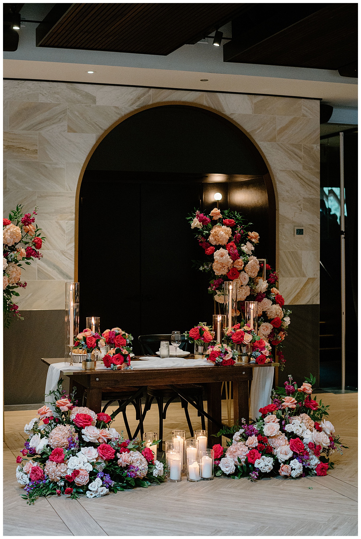 sweetheart table surrounded by lush floral arches and arrangements by Midwest wedding photographer