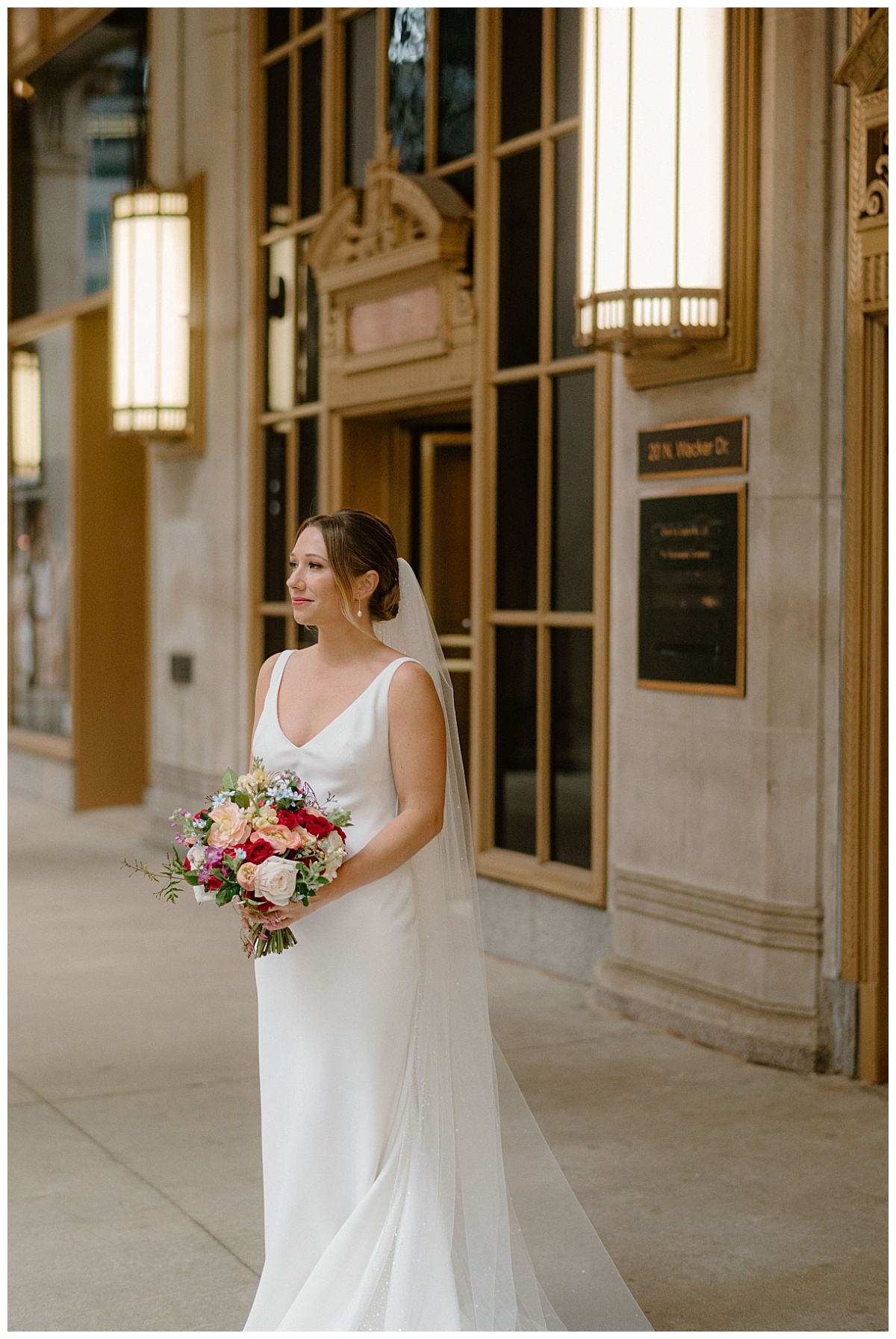 bride holds bouquet as she looks down the sidewalk at Chicago Winery