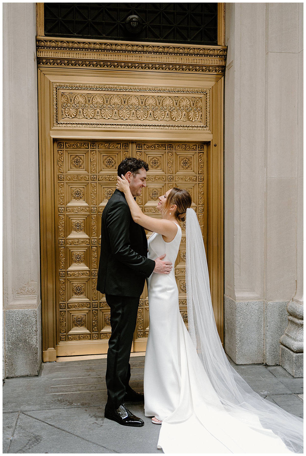couple looks at each other in front of ornate gold door by Indigo Lace Collective