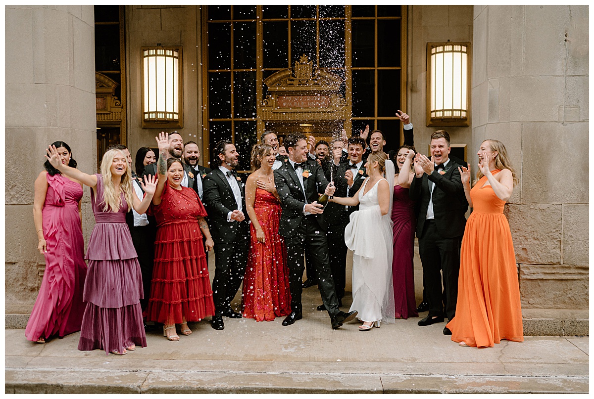 bridal party celebrates as groom sprays champagne at Chicago Winery