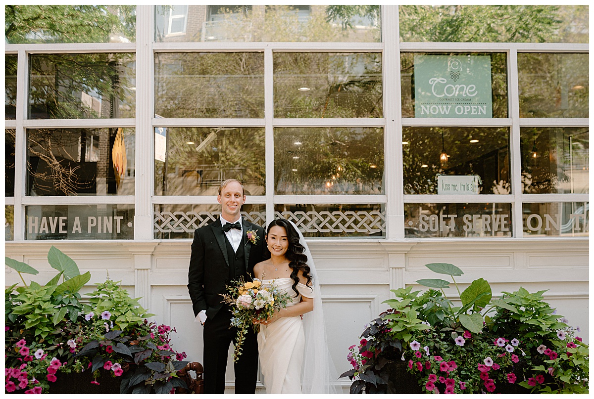 couple smiles outside building with many windows during Lacuna Lofts wedding
