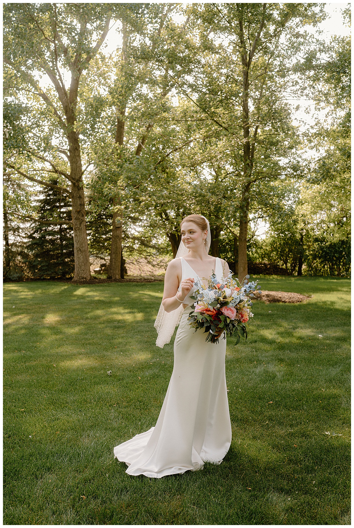 bride holds floral bouquet as she looks to the side by  Midwest wedding photographer