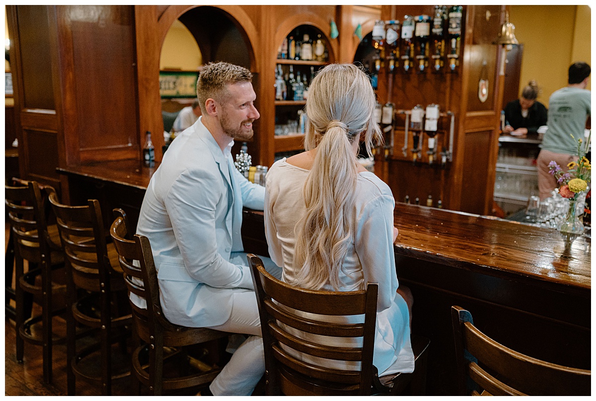 couple sits at bar together during Downtown Fort Wayne Courthouse Elopement