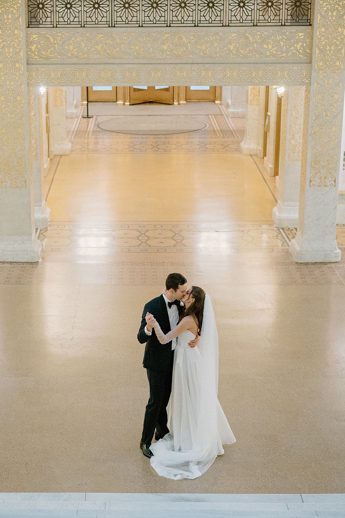 bride and groom dance and kiss in tall building before Galleria Marchetti Reception